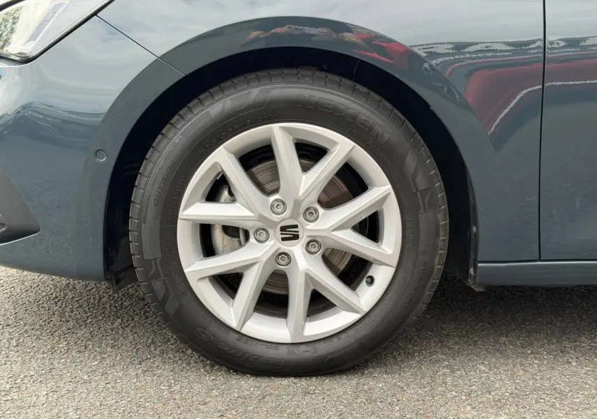 Gros plan sur la roue avant gauche et la jante alu grise d'une SEAT LEON gris magnétique métallisée.