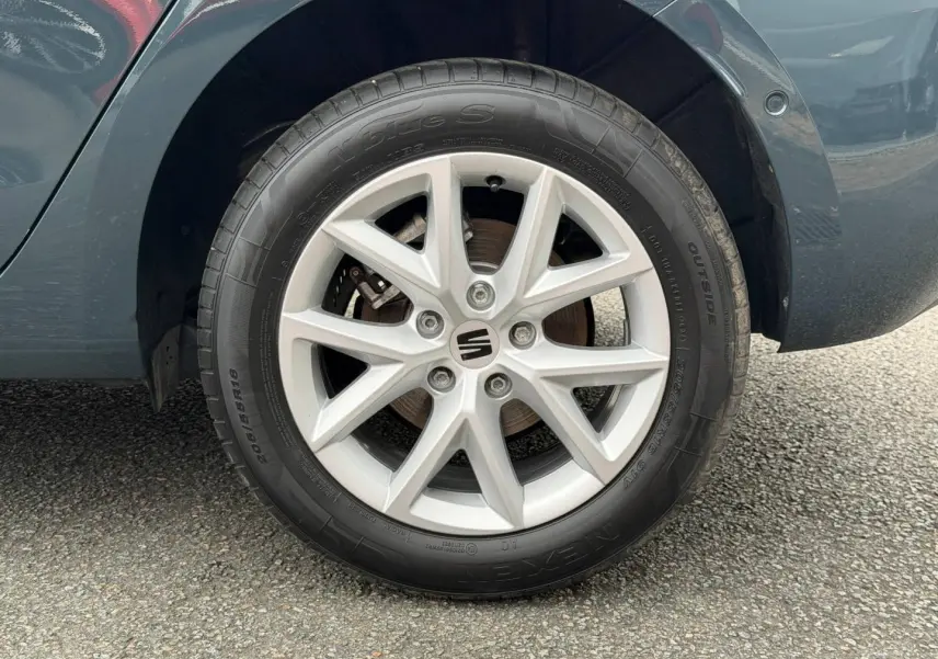 Gros plan sur la roue arrière droite de la SEAT LEON gris magnétique métallisé avec jante alu à 5 branches doubles.