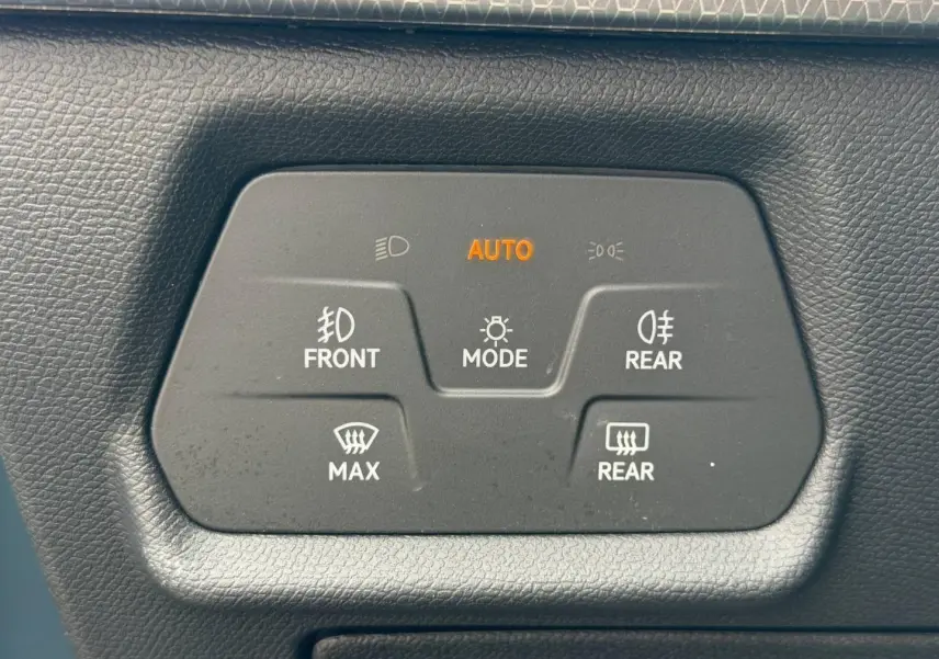 Panneau de commandes d'éclairage et dégivrage avec mode automatique, sur tableau de bord noir d'une SEAT Leon gris magnétique.