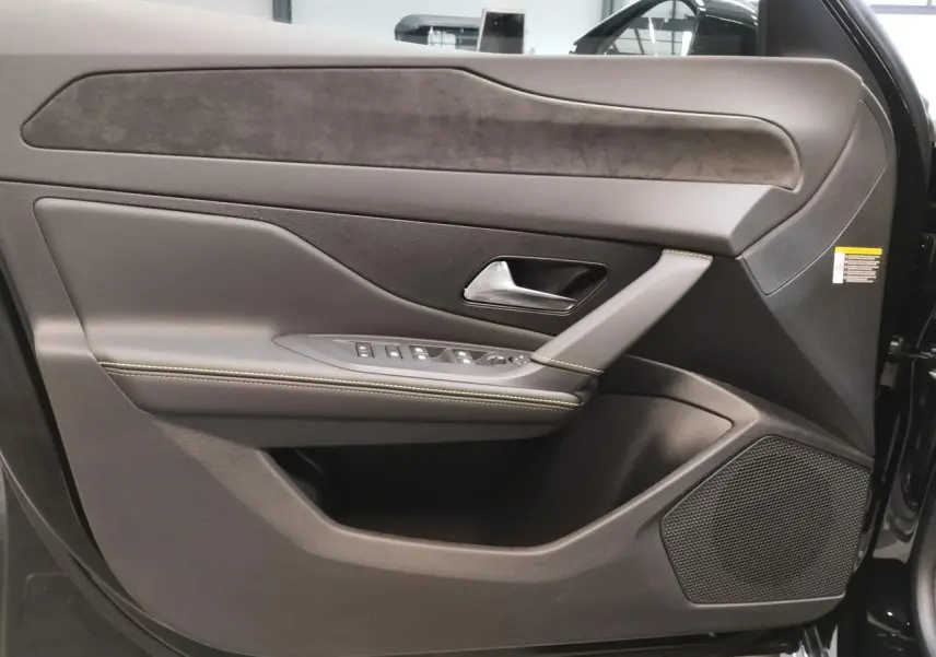 Porte avant droite de Peugeot 308 1.2i Hybrid noire, avec garniture en similicuir et alcantara, commandes électriques et haut-parleur intégré.