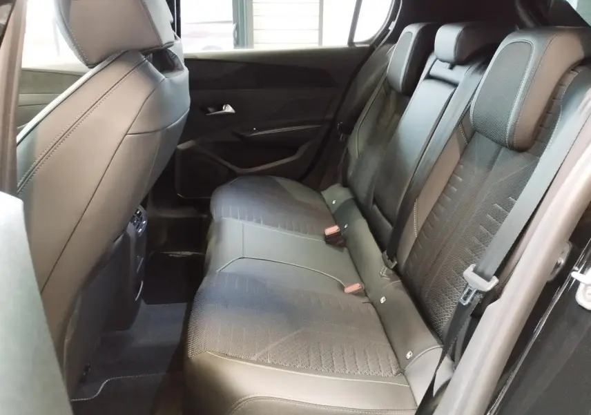 Vue intérieure côté droit des sièges arrière noirs en tissu et similicuir du Peugeot 308 hybride 2026.