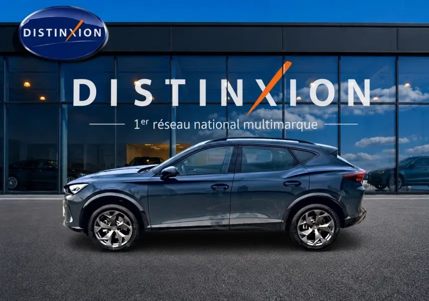 Vue de profil côté gauche d'un CUPRA Formentor 1.5 etsi hybrid bleu fjord devant une vitrine Distinxion.