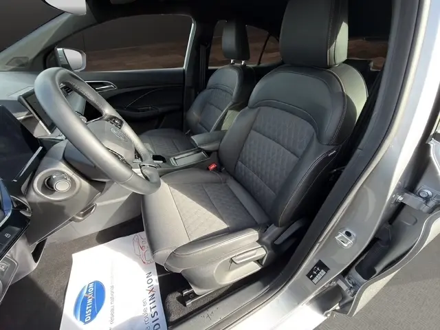 Vue intérieure côté conducteur du MG3 gris clair 2025, mettant en valeur les sièges avant en tissu et cuir avec détails matelassés.