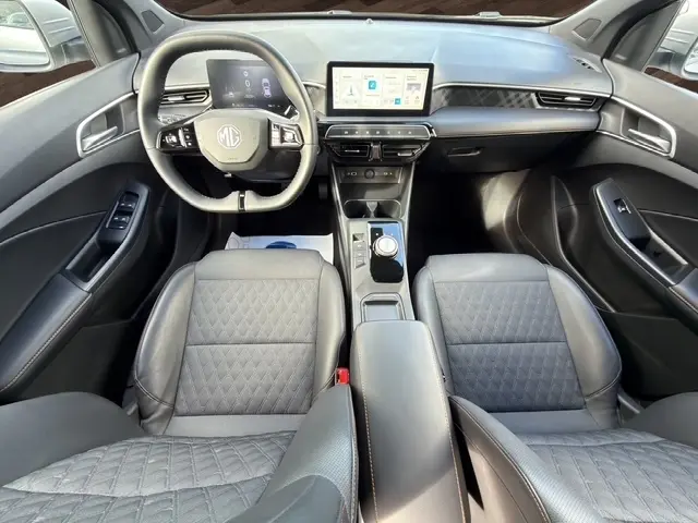 Vue intérieure avant de la MG3 1.5L Hybrid+ Luxury 2025, sièges noirs matelassés et écran tactile central lumineux.