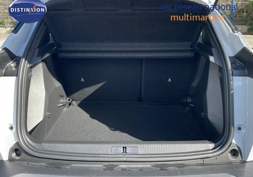 Coffre ouvert vu de l'arrière d'un Peugeot 2008 blanc Okenite Metal, montrant l'espace de chargement vide.