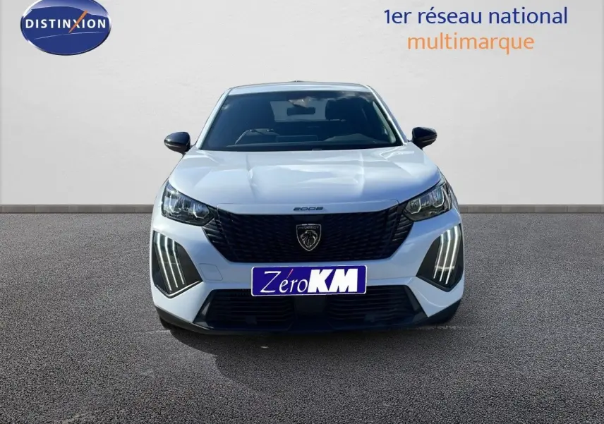 Vue frontale d'un Peugeot 2008 blanc Okenite Metal avec feux LED distinctifs et calandre noire élégante.