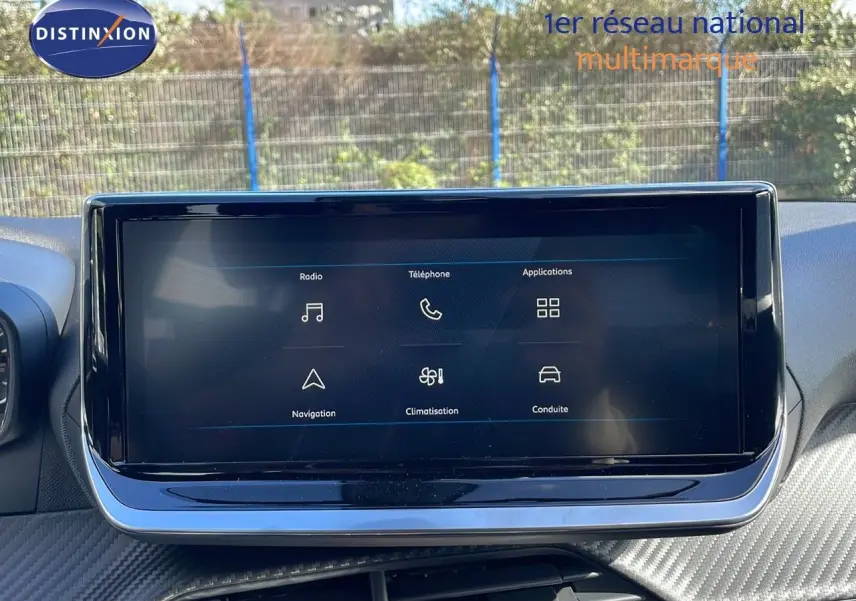 Écran tactile central du tableau de bord du Peugeot 2008 2025, avec interface multimédia affichée en extérieur.