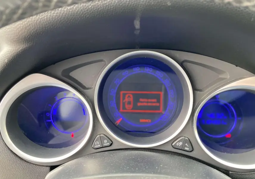 Tableau de bord du DS4 2016 avec compteurs ronds lumineux bleus et écran central affichant un message d'alerte.