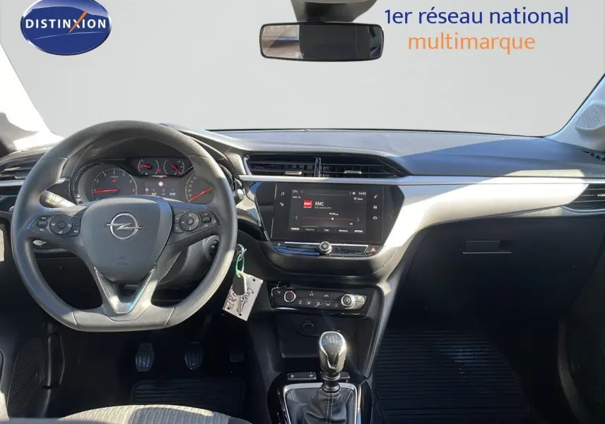 Intérieur de l'Opel Corsa blanc glacier 2022, vue frontale du poste de conduite avec volant multifonction et écran tactile central.