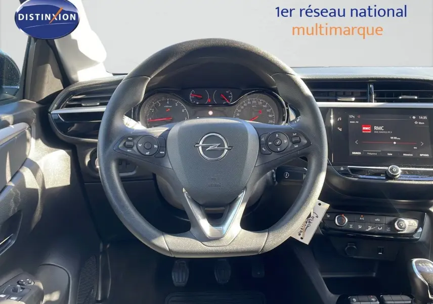 Vue intérieure centrée sur le volant Opel d'une Corsa blanche glacier 2022 avec tableau de bord digital et commandes au volant.