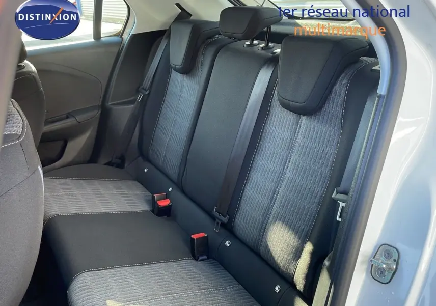 Vue intérieure sur les sièges arrière en tissu gris et noir de l'Opel Corsa blanc glacier avec porte arrière ouverte.