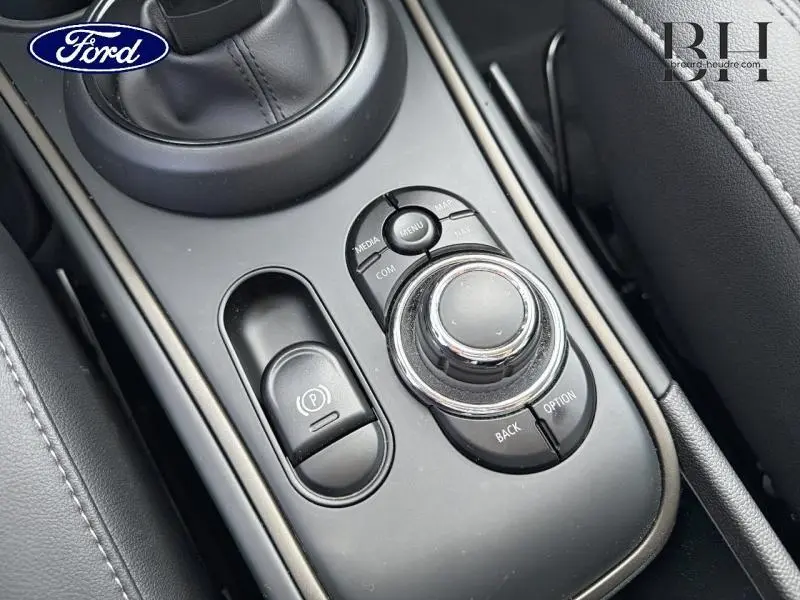 Vue rapprochée de la console centrale noire du MINI Countryman 2023 avec commandes multimédia et frein électrique.