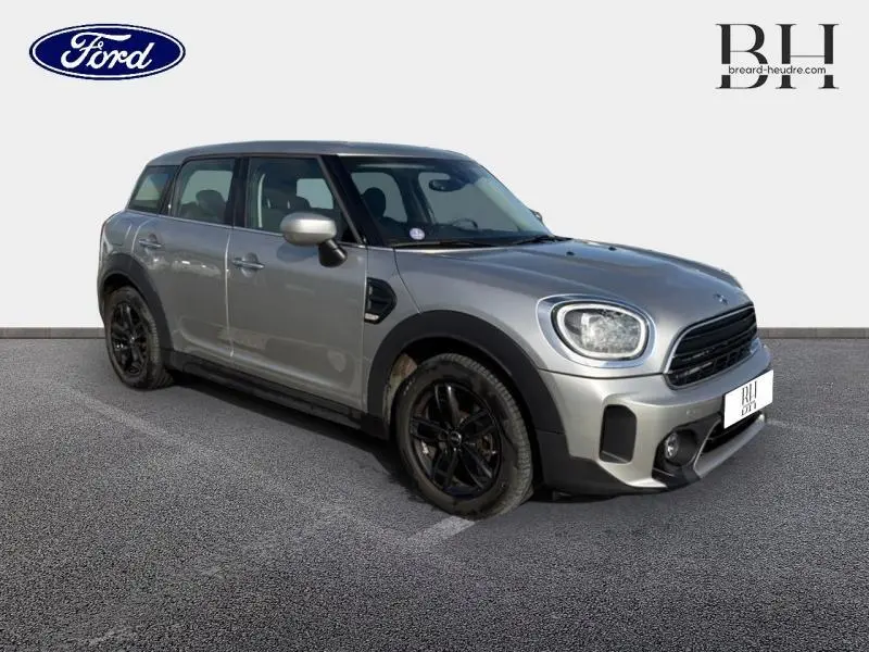 Vue 3/4 avant droit d'une MINI Countryman 2023 Melting Silver III avec jantes noires et calandre chromée.