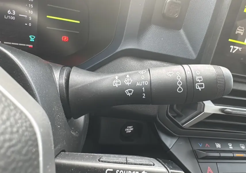 Gros plan sur la commande des essuie-glaces du tableau de bord du Dacia Duster 2025, intérieur noir.