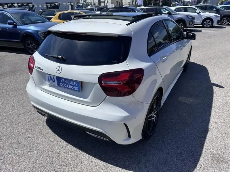 Vue 3/4 arrière droite d'une Mercedes Classe A 200 d Fascination blanche, avec vitres teintées et jantes sport noires.