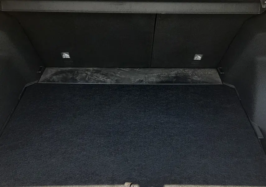 Coffre ouvert vu de face du MG Motor ZS 1.5L Hybrid+ 2026 en Pebble Black Metal, intérieur noir et tapis de sol.