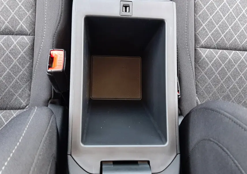 Vue plongeante sur la console centrale noire et les sièges en tissu gris à motifs du MG MOTOR ZS hybride 2026.