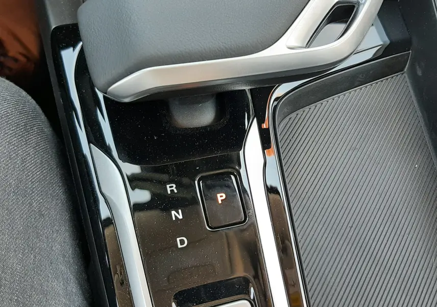 Gros plan sur la console centrale noire brillante du MG ZS 2026, avec levier de vitesses automatique et bouton start/stop vert.