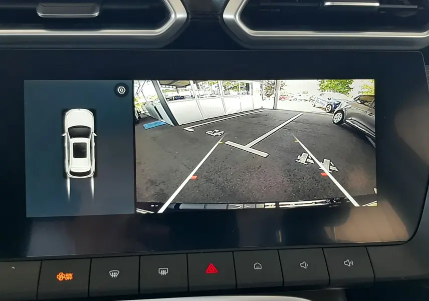Écran central du MG ZS 1.5L Hybrid+ 2026 montrant la caméra de recul avec vue sur un parking, intérieur noir.