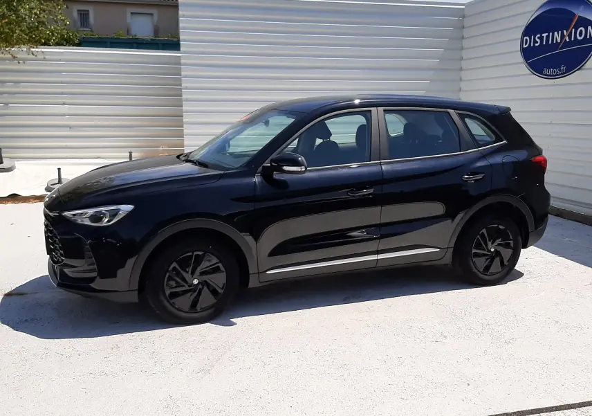 Vue de profil côté gauche du MG ZS 1.5L Hybrid+ 197ch en Pebble Black Metal, avec jantes noires et carrosserie brillante.