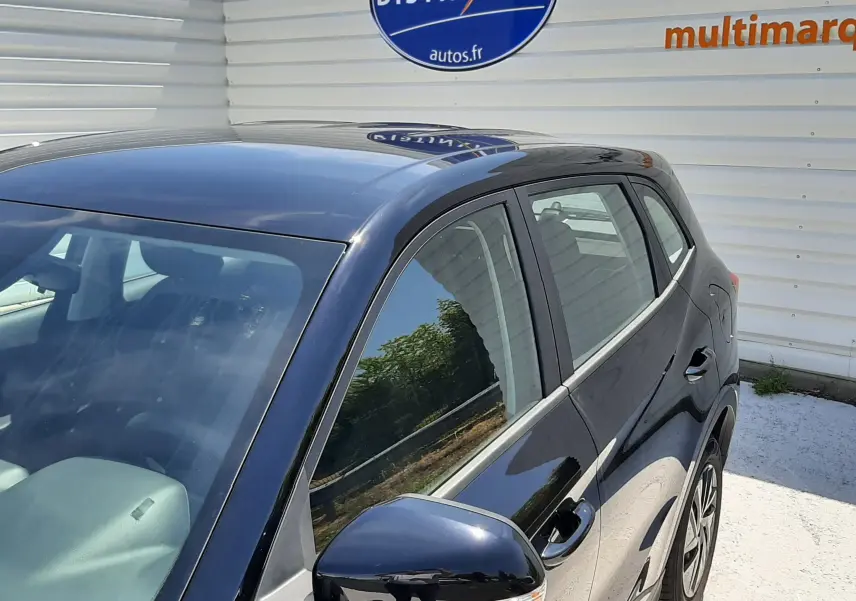 Vue 3/4 avant droit du MG MOTOR ZS 1.5L HYBRID+ 197CH en Pebble Black Metal, avec rétroviseur et jantes visibles.