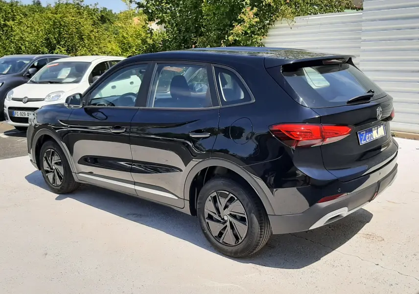 Vue 3/4 arrière droite du MG ZS 1.5L HYBRID+ 197CH en noir Pebble Black Metal avec jantes noires et feux arrière LED.
