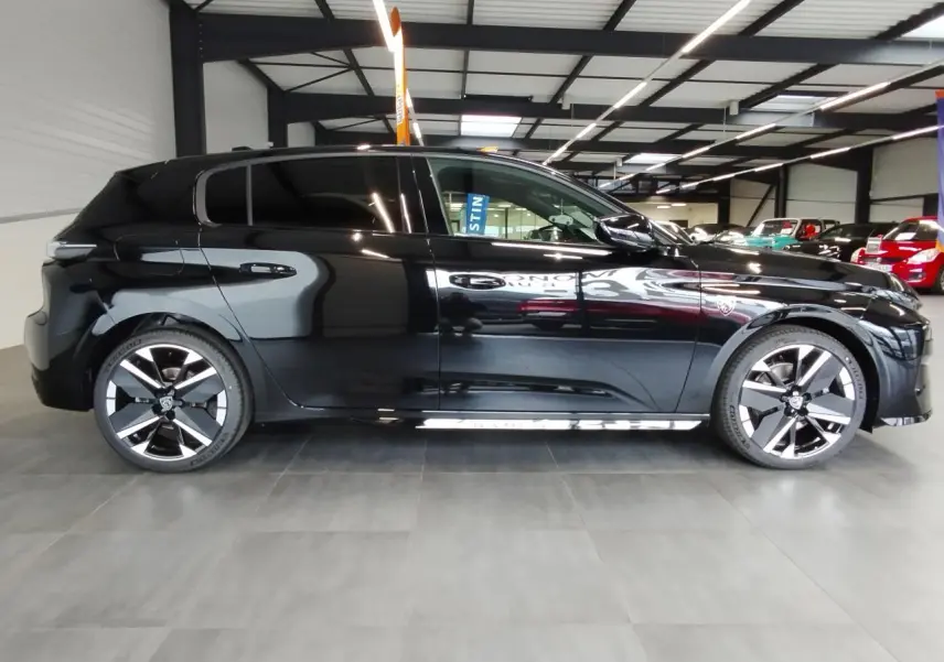 Peugeot 308 noir métal vue de profil côté gauche, avec jantes alliage bi-tons et détails noirs brillants.