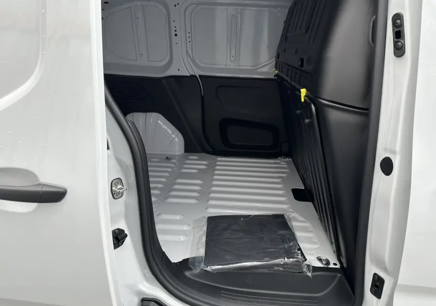 Intérieur du fourgon blanc Peugeot Partner BlueHDi 100ch M 2024 vu côté droit, montrant l'espace de chargement vide.
