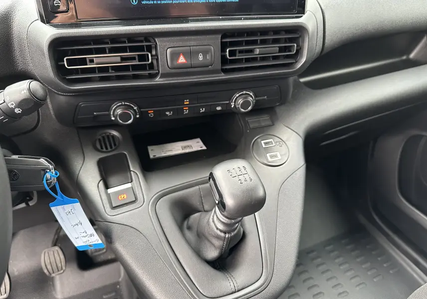 Intérieur du Peugeot Partner Fourgon 2024 montrant la console centrale avec levier de vitesse manuel et commandes de climatisation.