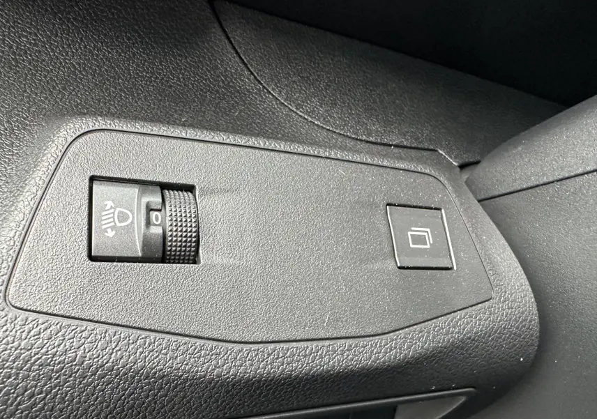 Gros plan sur les commandes de réglage des phares et du tableau de bord du Peugeot Partner Fourgon blanc 2024.