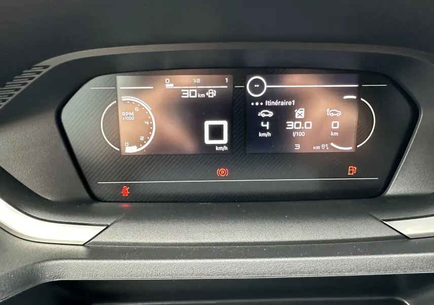 Tableau de bord numérique du Peugeot Partner Fourgon blanc 2024 affichant vitesse et consommation.