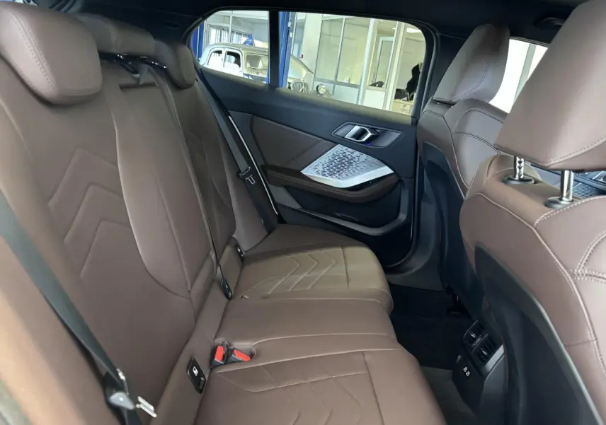 Vue intérieure côté droit des sièges arrière en cuir marron de la BMW Série 1 120d M Sport 2025.