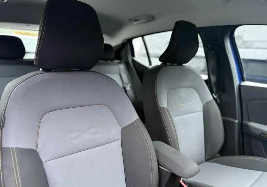 Vue intérieure des sièges avant gris clair et noir avec surpiqûres contrastantes dans une Dacia Sandero Stepway Bleu Iron.