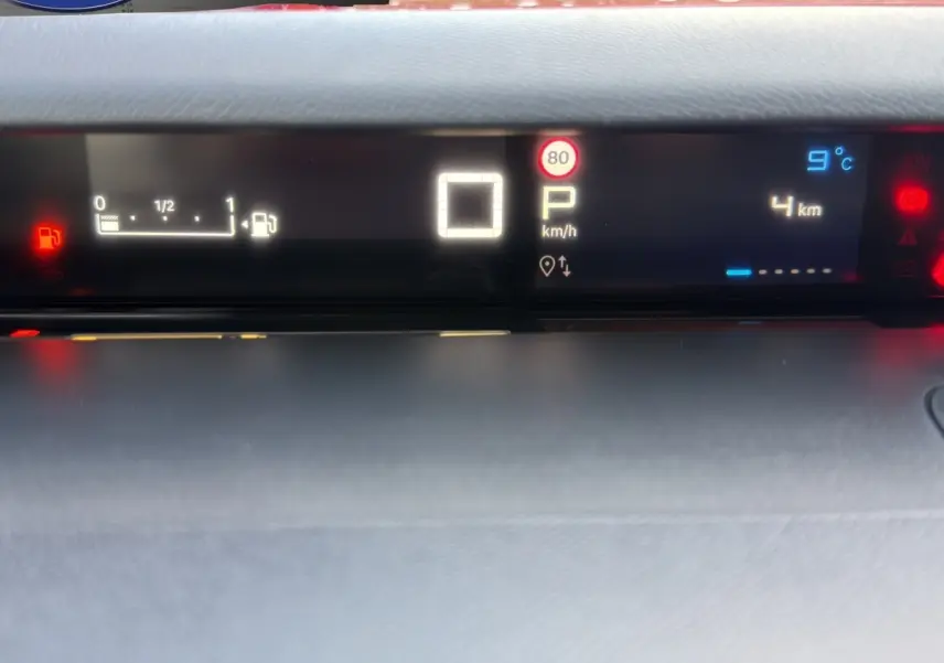Tableau de bord numérique de Citroën C3 hybride rouge, affichant vitesse, température et niveau carburant.