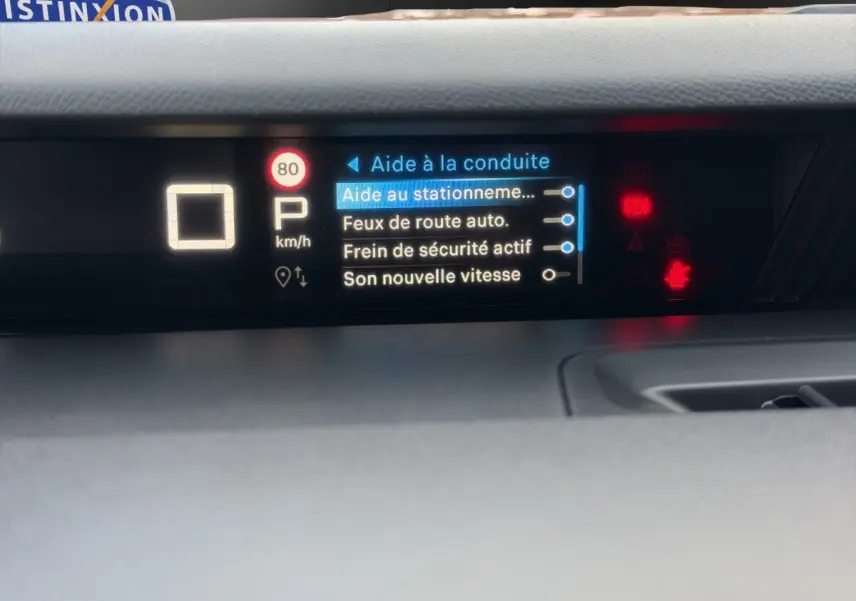 Écran central du tableau de bord de la Citroën C3 hybride rouge, affichant les aides à la conduite activées.