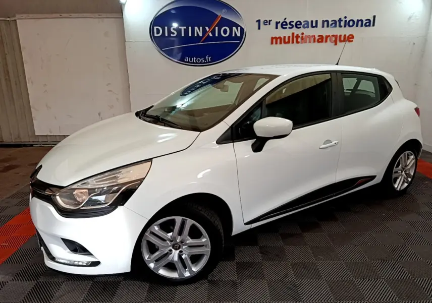 Renault Clio Business TCe 90 blanche vue de 3/4 avant droit dans un showroom avec logo Distinxion en arrière-plan