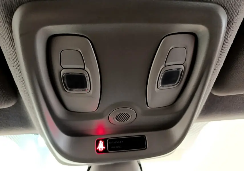 Vue rapprochée du plafonnier gris avec commandes d'éclairage et témoin de ceinture allumé dans une Renault Clio blanche 2019.