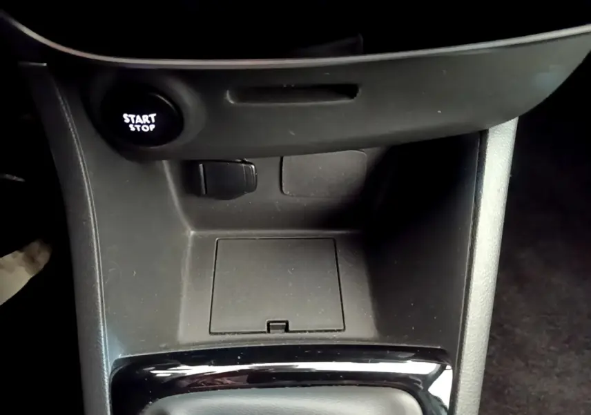 Gros plan sur la console centrale noire de la Renault Clio Business avec bouton Start/Stop éclairé.