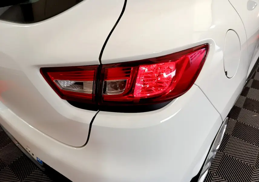 Gros plan sur le feu arrière droit d'une Renault Clio Business TCe 90 blanche, avec la trappe à carburant visible sur le côté.