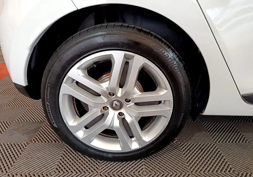 Gros plan sur la roue avant droite de la Renault Clio Business TCe 90 blanche, avec jante alliage et logo Renault visible.