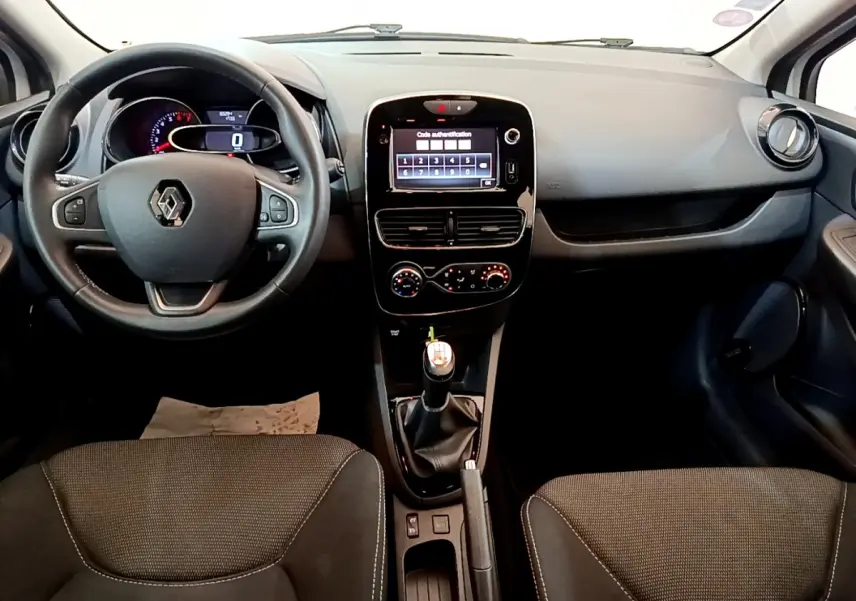 Vue frontale de l'intérieur noir de la Renault Clio Business TCe 90 2019, avec volant cuir et écran tactile central allumé.