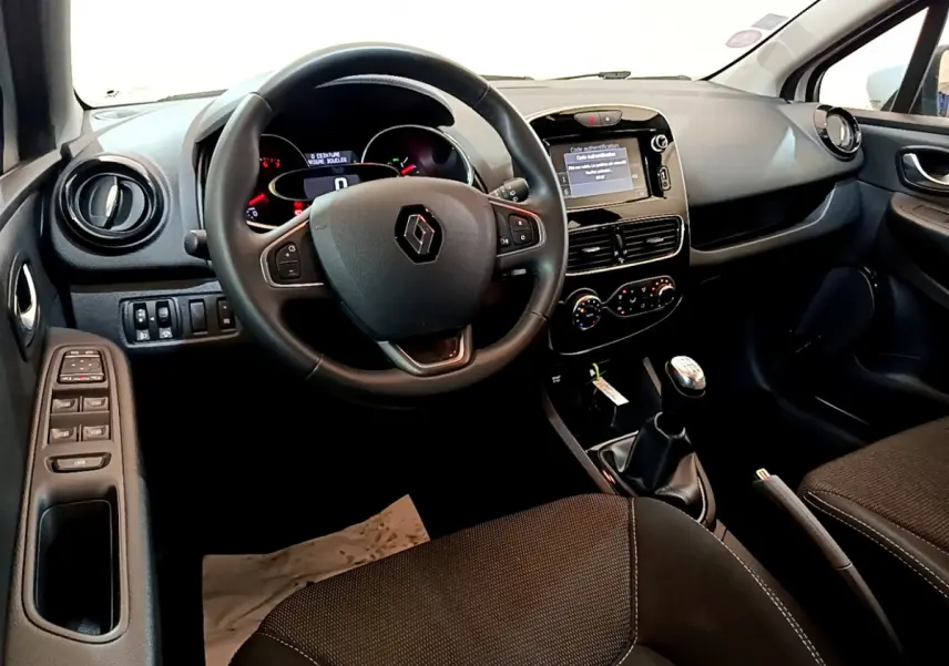 Intérieur avant de la Renault Clio Business TCe 90 2019, tableau de bord noir avec écran tactile et volant cuir multifonctions.