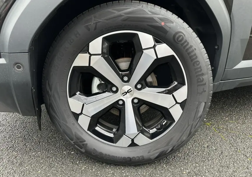 Gros plan sur la jante alliage diamantée 18” du Dacia Duster noir, avec pneu Continental visible côté gauche.