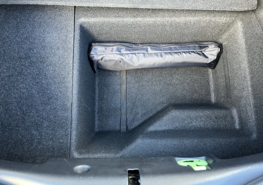 Coffre ouvert de la Jaguar F-TYPE II Coupe 2.0T 2018 en Corris Grey, montrant un rangement avec une trousse noire.