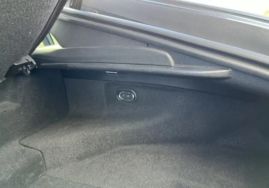 Vue intérieure du coffre arrière de la Jaguar F-TYPE II Coupé 2.0T 300 BVA8, revêtement noir et espace de rangement.