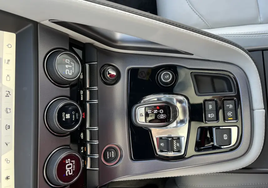 Vue rapprochée de la console centrale en cuir gris clair de la Jaguar F-TYPE II Coupe, avec commandes de climatisation et levier de vitesse.