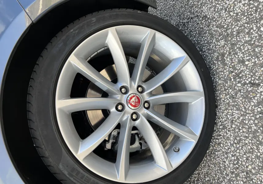 Gros plan sur la jante 19 pouces argentée à 10 branches de la Jaguar F-TYPE II Coupe Corris Grey, avec logo central rouge.