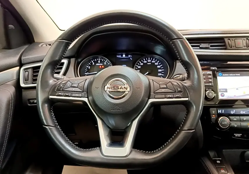 Vue intérieure centrée sur le volant cuir noir du Nissan Qashqai 1.3 DIG-T 140 Tekna avec tableau de bord et écran tactile.