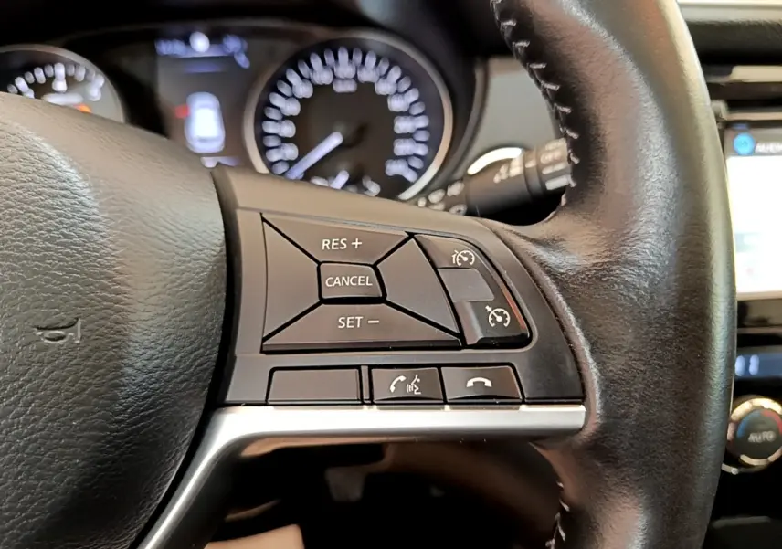 Gros plan sur le volant cuir noir du Nissan Qashqai 2019, avec commandes de régulateur de vitesse à droite.