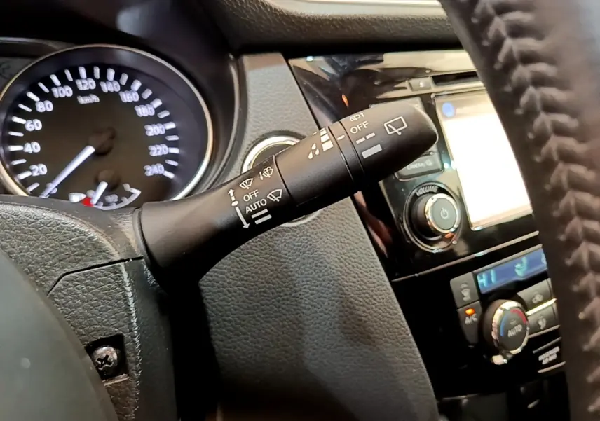 Gros plan sur la commande d'essuie-glace à gauche du volant dans l’habitacle du Nissan Qashqai blanc 2019.